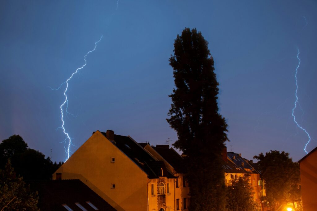 Blesk počas búrky nad domami v noci