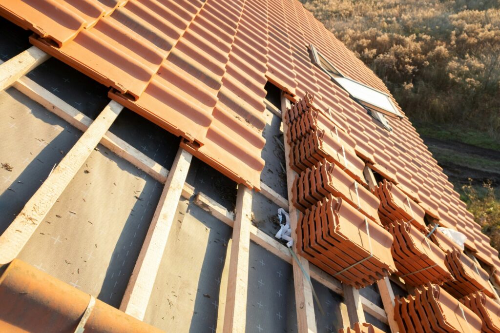 Stavebný materiál uložený na šikmej streche rodinného domu